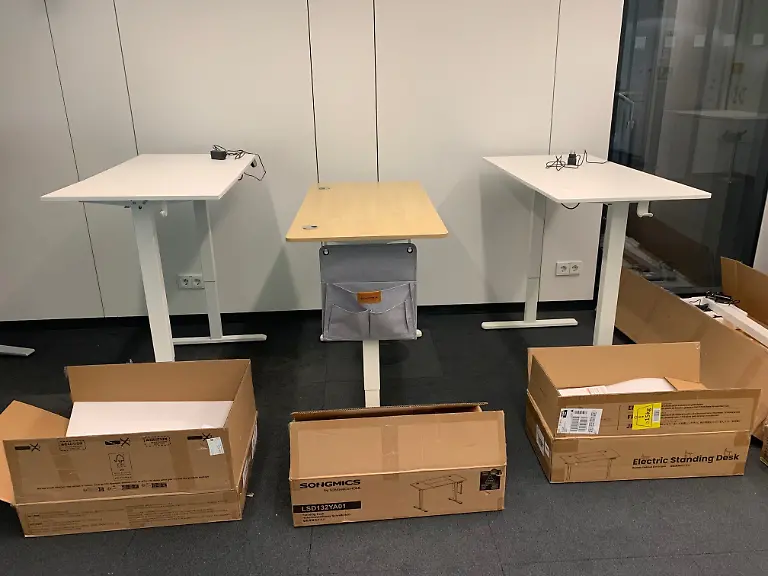 Alle drei höhenverstellbaren Schreibtische mit Kartons